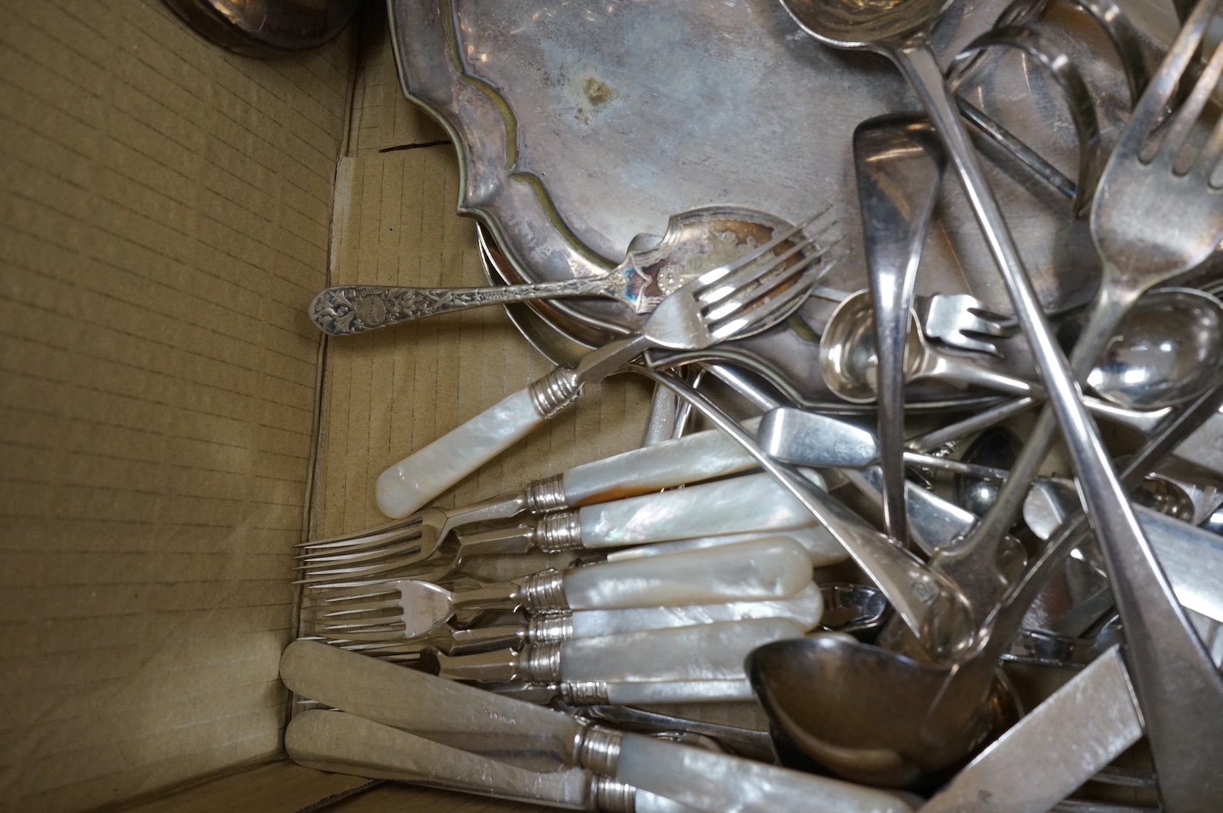 A group of assorted plated ware, including a pair of candlesticks, a salver, toast rack and cutlery including set of mother of pearl handled dessert eaters, together with a George V silver mounted trinket box and two sil